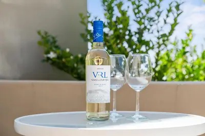 a bottle of wine sitting on a table with two wine glasses at Suikerbossie 83 in Cape Town