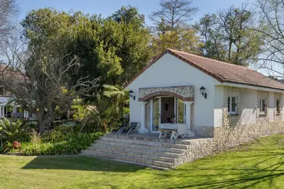 a small white house with a stone wall at Bonne Chance Luxury Estate in Lynedoch