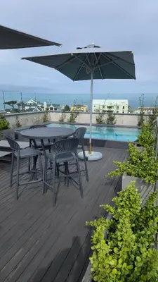 a patio with a table and chairs and an umbrella at Whale Watchers studio in Hermanus