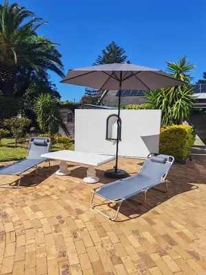 a picnic table and two chairs and an umbrella at Somerset west Stay 1 in Somerset West