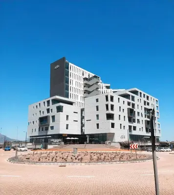 a large white building in front of a parking lot at Luxury Three Bedroom Axis- Ocean and Mountain Views in Cape Town