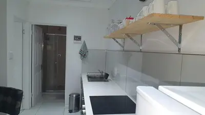 a kitchen with white walls and a white counter top at Comfey Stay in Somerset West