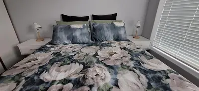 a bedroom with a bed with a floral bedspread at 33 on Vermont in Hermanus