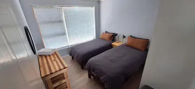 two beds in a room with a window at 33 on Vermont in Hermanus