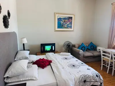 a bedroom with a large bed and a couch at Peaceful getaway in Cape Town