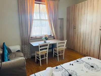 a living room with a table and chairs and a window at Peaceful getaway in Cape Town
