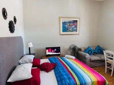 a bedroom with a colorful bed and a couch at Peaceful getaway in Cape Town