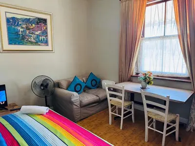 a room with a bed and a table and a couch at Peaceful getaway in Cape Town