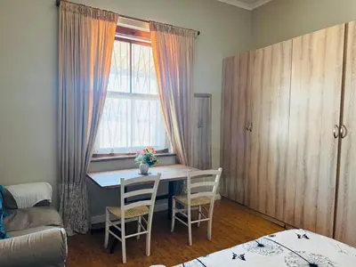a room with a table and chairs and a window at Peaceful getaway in Cape Town