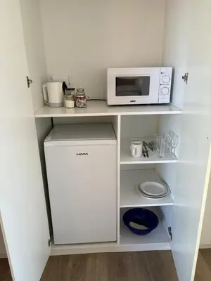 a small kitchen with a microwave and a refrigerator at Cozy en-suite room in Wellington with own entrance in Wellington