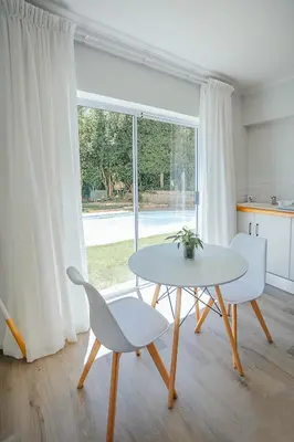 a white table and chairs in a room with a window at On Helderberg in Somerset West