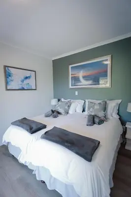 a bedroom with two large white beds with pillows at On Helderberg in Somerset West