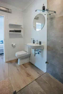 a bathroom with a toilet and a sink and a mirror at On Helderberg in Somerset West