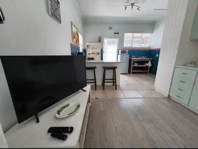 a living room with a large flat screen tv at Crinum House and cottages in Bloubergstrand in Cape Town