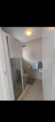 a bathroom with a shower and a toilet in it at Crinum House and cottages in Bloubergstrand in Cape Town