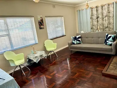 a living room with a couch and a table and chairs at One Bedroom House in Goodwood