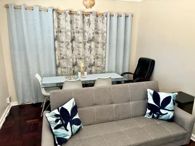 a living room with a couch and a table at One Bedroom House in Goodwood