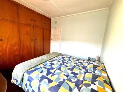 a bedroom with a bed with a colorful comforter at One Bedroom House in Goodwood