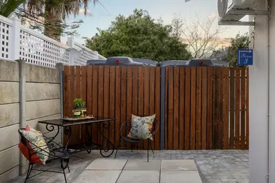 a wooden fence with a table and two chairs at Twelve on Arum in Somerset West