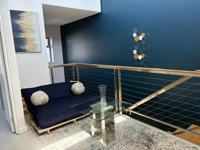a living room with a blue couch and a glass table at Ultra Luxury 3 Bed Knightsbridge Penthouse in Cape Town