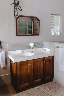 a bathroom with a sink and a mirror at Courchevel Cottages in Franschhoek