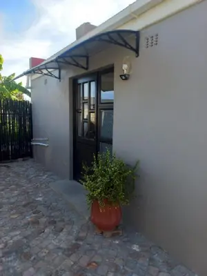 a door to a house with a potted plant in a pot at Rosa Villa in Hermanus