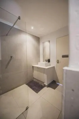 a bathroom with a sink and a shower at Surfers Lodge in Cape Town