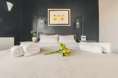 a bedroom with a white bed with towels on it at Surfers Lodge in Cape Town