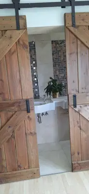 a large wooden door in a room with a sink at Firehouse selfcatering Garden Cottage no 1 in Wellington