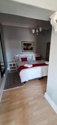 a bedroom with two beds with red and white sheets at Firehouse selfcatering Garden Cottage no 1 in Wellington