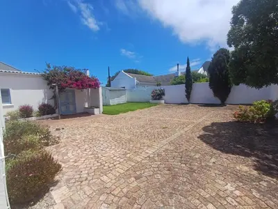 a driveway of a house with a white fence at Holiday Vibe in Hermanus