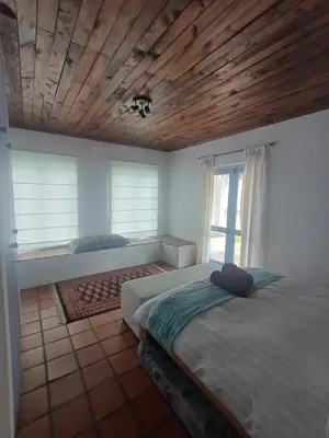 a bedroom with two beds and a wooden ceiling at Holiday Vibe in Hermanus