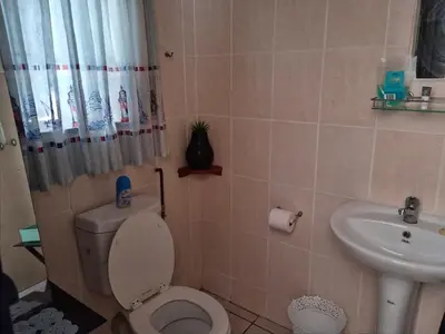 a bathroom with a toilet and a sink at UITZICHT STAY Durbanville Pet Friendly in Oakdale