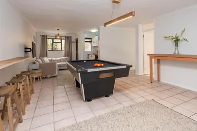 a living room with a pool table in it at Fun in the Voelklip Sun in Hermanus