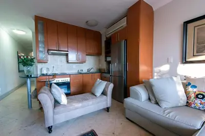 a living room with a couch and a kitchen at Oude Hoek, Stellenbosch Central in Stellenbosch
