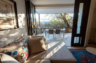 a living room with a couch and a large window at Oude Hoek, Stellenbosch Central in Stellenbosch
