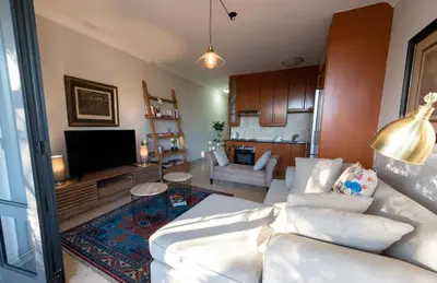 a living room with a white couch and a tv at Oude Hoek, Stellenbosch Central in Stellenbosch