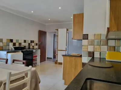 a kitchen with a table and a counter top at 'Country Beach House' - Traditional Family Vacation Home for 6 - Near Beach in Gordonʼs Bay