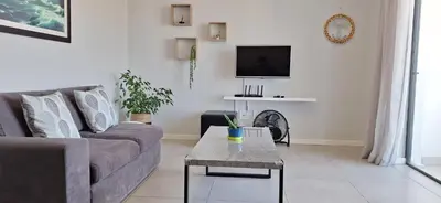 a living room with a couch and a table at Sound of the surf in Cape Town