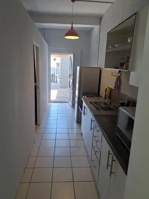 a kitchen with a tile floor and a hallway at Comfort and calm zone in Cape Town