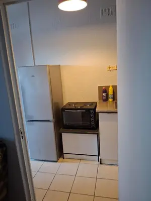 a small kitchen with a microwave and a refrigerator at Comfort and calm zone in Cape Town