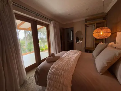 a bedroom with a large bed with a large window at Self Check-in River View Suite in Wellington