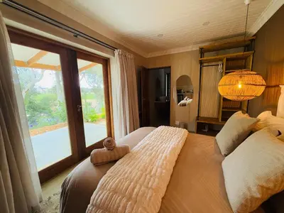 a bedroom with a large bed with a large window at Self Check-in River View Suite in Wellington