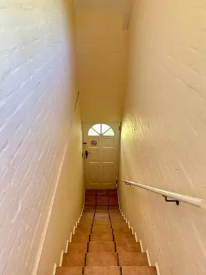 a hallway with a white door and a staircase at The Loft House in Cape Town