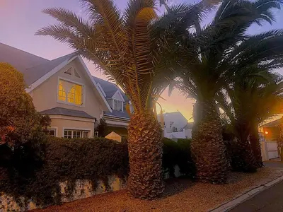 two palm trees in front of a house at The Loft House in Cape Town