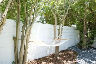 a hammock hanging between two trees in a fence at Villa on Flamingo Vlei in Cape Town