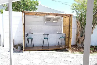 a bar in a shed with two stools at Villa on Flamingo Vlei in Cape Town