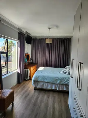a bedroom with a bed and a window at St James home in Somerset West