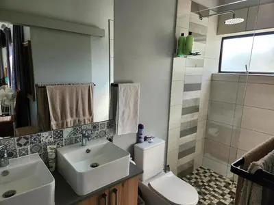 a bathroom with a sink and a toilet and a shower at St James home in Somerset West