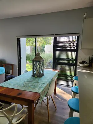 a dining room with a table and some chairs at St James home in Somerset West